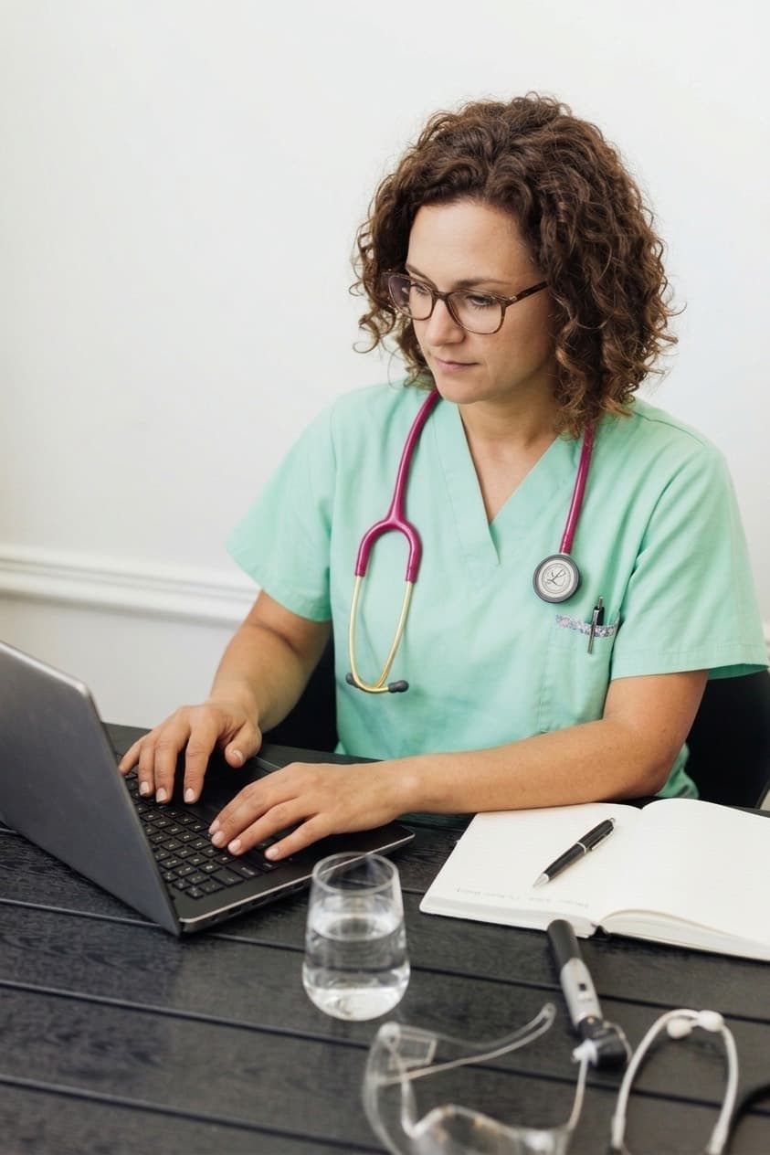 Profesional de enfermería revisando el estado de sus pacientes en el computador